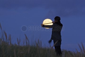 Person measuring the diameter of the full moon