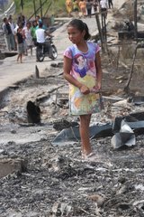 Girl in the rubble of a house fire Sumatra Indonésie