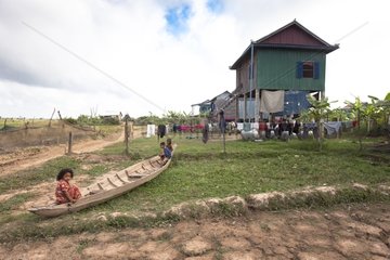 Children playing on a boat near a house Cambodia
