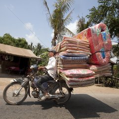 Transporting mattresses and mats on a motorcycle Cambodia
