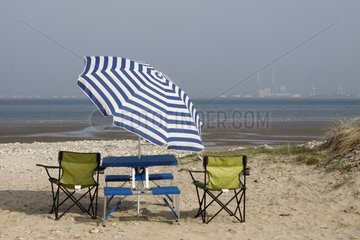 Table and chairs under an umbrella facing the sea Normandy