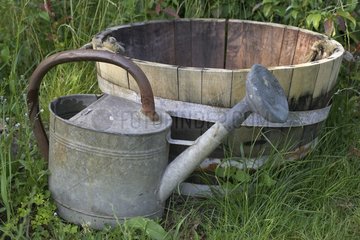 Zinc watering can and wooden bucket in the grass France