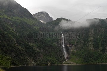 Oo lake and waterfall in the morning mist Pyrenees France