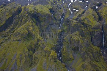Cascade through a volcanic landscape in southern Iceland