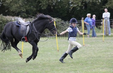 Girl running race black pony mid air Gymkhana UK