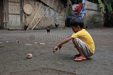 Boy playing with a top Gangga Lombok Indonesia