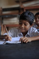 Schoolboy writing in class Gangga Lombok Indonesia