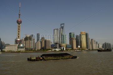 Barges loaded with coal and modern Shanghai in China
