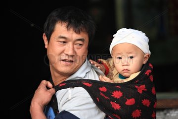 Man carrying baby on her back to Namshan Burma