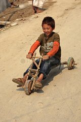 Child on a bicycle built house with pieces of wood Burma