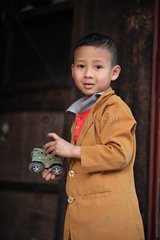 Chinese child playing with a plastic army tank Burma