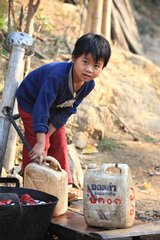 Girl filling water bottles at water Burma