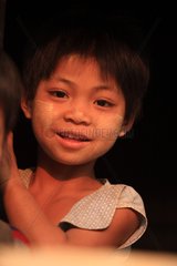 Portrait of a girl smiling at the window in Burma