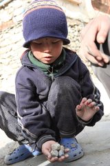 Child playing with pebbles Manang Nepal Himalayas