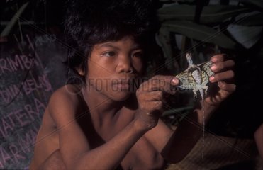 Boy playing with flying lizard Bukit Duabelas NP Sumatra
