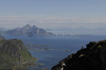 Hiker admiring the panorama in Lofoten Norway