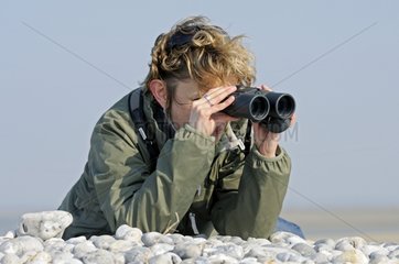 Watching through binoculars along the Bay of Somme