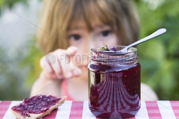 Little girl scared by a wasp in a jam jar