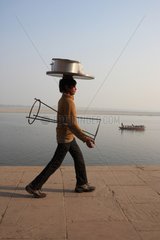Man carrying cooking utensils Varanasi India