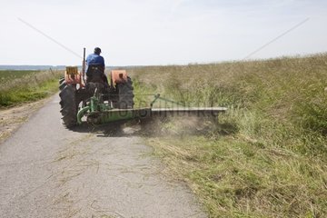 Mowing roadsides at the edge of fields France