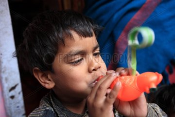 Portrait of boy blowing on a toy Haridwar India