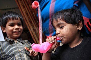 Portrait of boys blowing on a toy Haridwar India