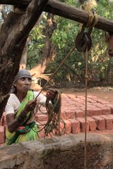 Women in saris drawing water at wells Ganpatipule India