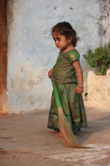 Girl sweeping the floor Vijayanagara Hampi India