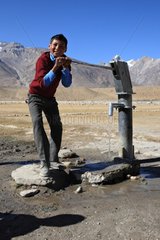 Schoolboy drawing water Zanskar Ladakh Himalayas India