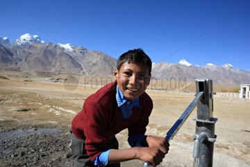 Schoolboy drawing water Zanskar Ladakh Himalayas India