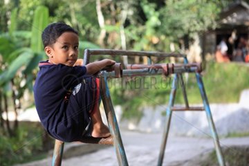 Boy playing on a porch Bukittinggi Sumatra Indonesia