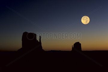 The moon and the Mitten and Merrick mesas in Monument Valley