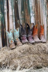 Cowboy boots on a bale of straw Wyoming USA