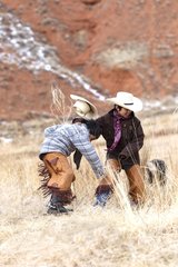 Young Cowboys playing together in a meadow Wyoming USA