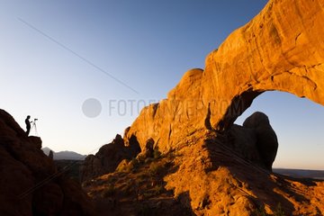 Photographer and sandstone arch Arches NP USA