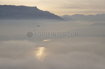 Morning fog on lake Bourget and airliner France