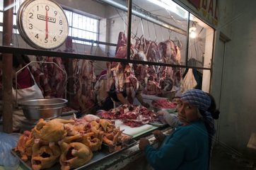 Woman in front of a butcher's stall Guatemala