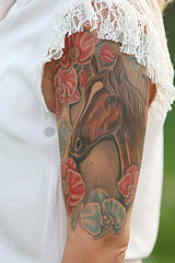Hannover  Deutschland  Pferde-Tattoo auf dem Oberarm einer Frau