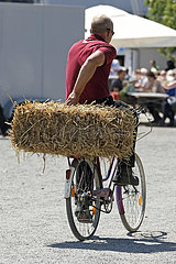 Hannover  Deutschland  Fahrradfahrer transportiert einen Strohballen