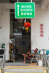 Singapur  Republik Singapur  Mann sitzt auf einem Stuhl in Chinatown