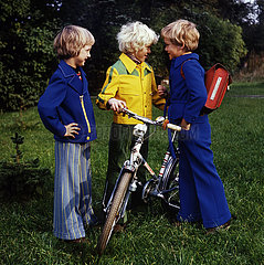 Berlin  Deutsche Demokratische Republik  Vorschulkinder stehen mit einem Fahrrad auf einer Wiese
