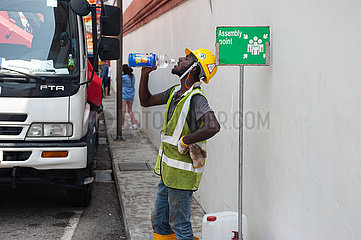 Singapur  Republik Singapur  Arbeiter trinkt Wasser aus einer Flasche in Chinatown