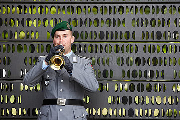 Berlin  Deutschland - Soldat des Stabsmusikcorps mit Trompete vor dem Ehrenmal der Bundeswehr.