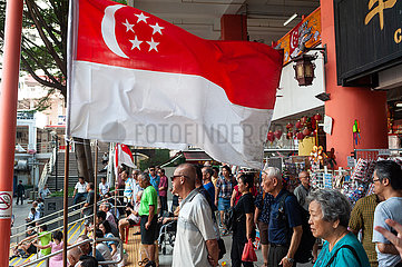 Singapur  Republik Singapur  Menschen unter einer Flagge in Chinatown