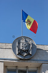 Republik Moldau  Chisinau - Nationalflagge und Nationalwappen der Republik Moldau auf dem Regierungsgebaeude