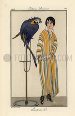 Woman in striped nightgown with pet parrot.