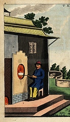 Chinese potter firing a porcelain plate in a furnace to fix the glaze on it.