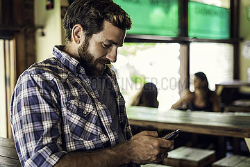 Man using smartphone in bar