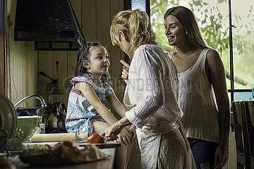 Mature woman talking her granddaughter in kitchen