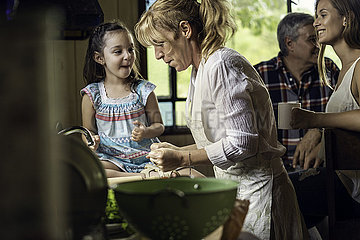 Mature woman cooking with her granddaughter in kitchen